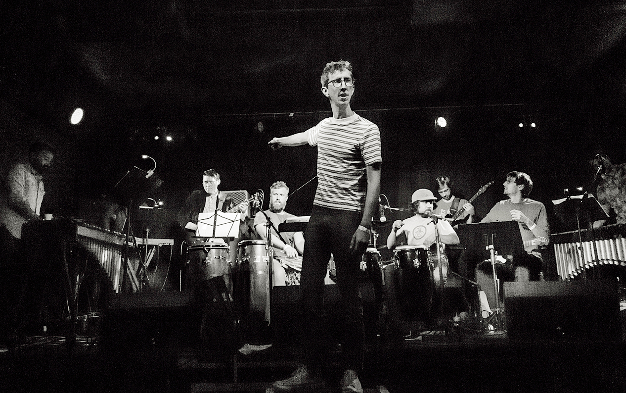 Black-and-white photo of Bay area-based musician Jordan Glenn instructing his band BEAK.